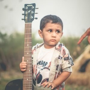 a young boy holding a guitar in his hands