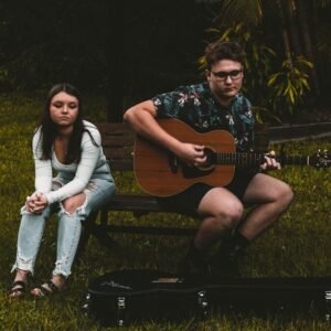 woman in black and white floral shirt sitting on brown wooden bench beside woman in white
